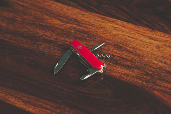 Image of a Swiss Army knife on a table. Community care software is a bit like a Swiss Army knife for homecare agencies.