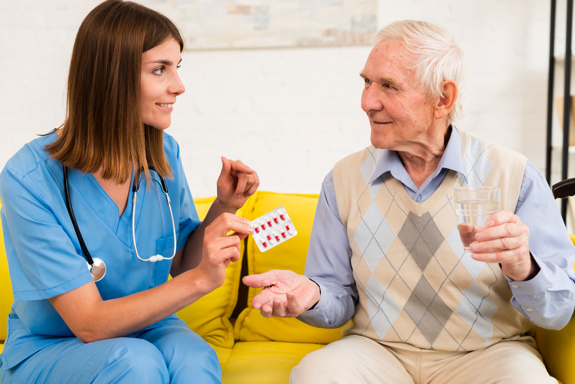 An elderly man discussing his medication with his home carer.