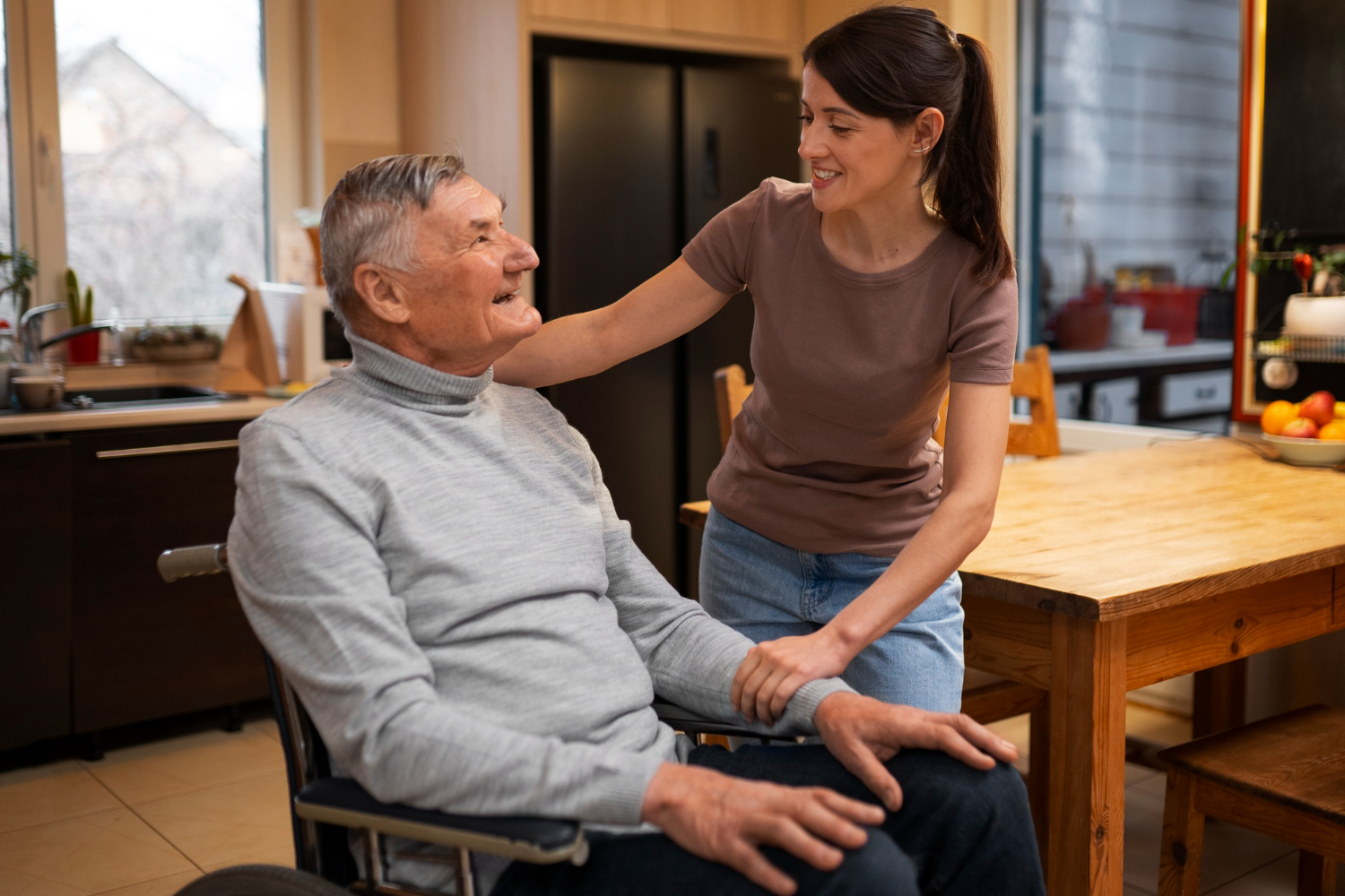 An elderly man in a wheelchair being reassured by his home carer. An elderly man in a wheelchair being reassured by his home carer.